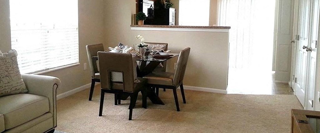 A dining room with a table set for four.