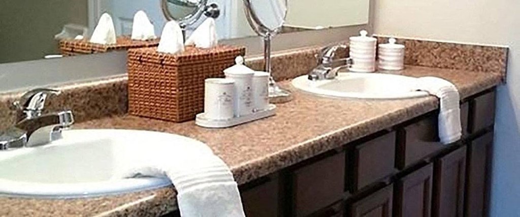 A bathroom with a brown counter top and a white sink.