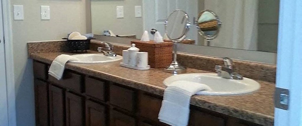 A bathroom with a brown counter top and a white sink.