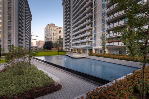A swimming pool surrounded by buildings and trees.
