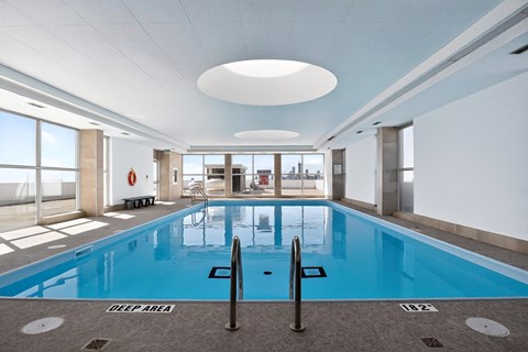 A large indoor swimming pool with a deep area marked on the floor.