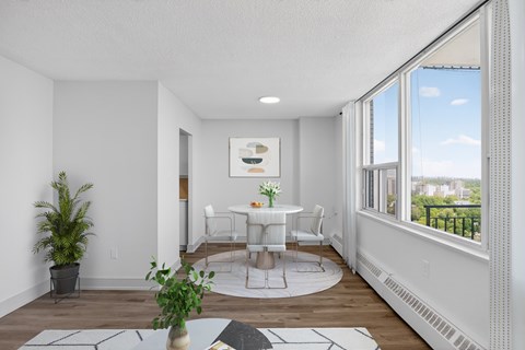 A dining room with a table set for two and a view of the city.