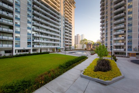 a view of a city street with high rise buildings and a park