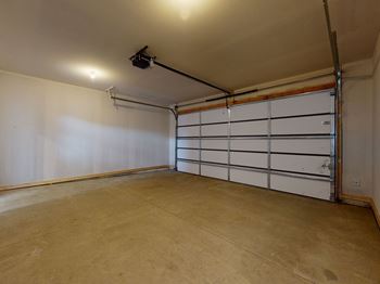 A large empty room with a white door and a black pipe running along the ceiling.at Linc, Des Moines, IA 50309  