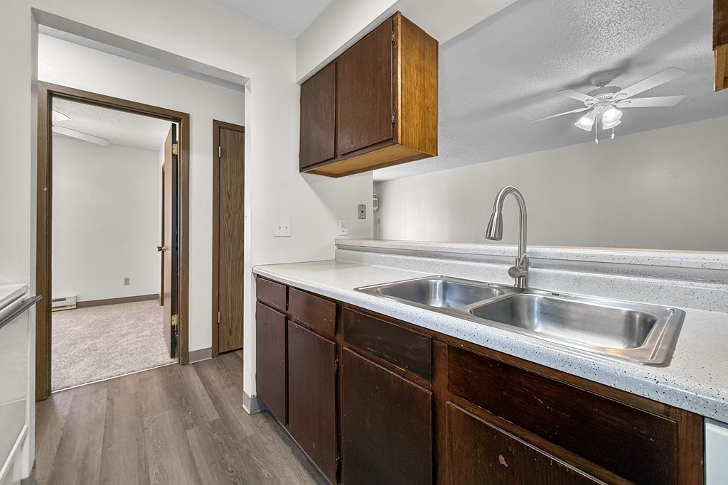 A kitchen with a sink and wooden cabinets.