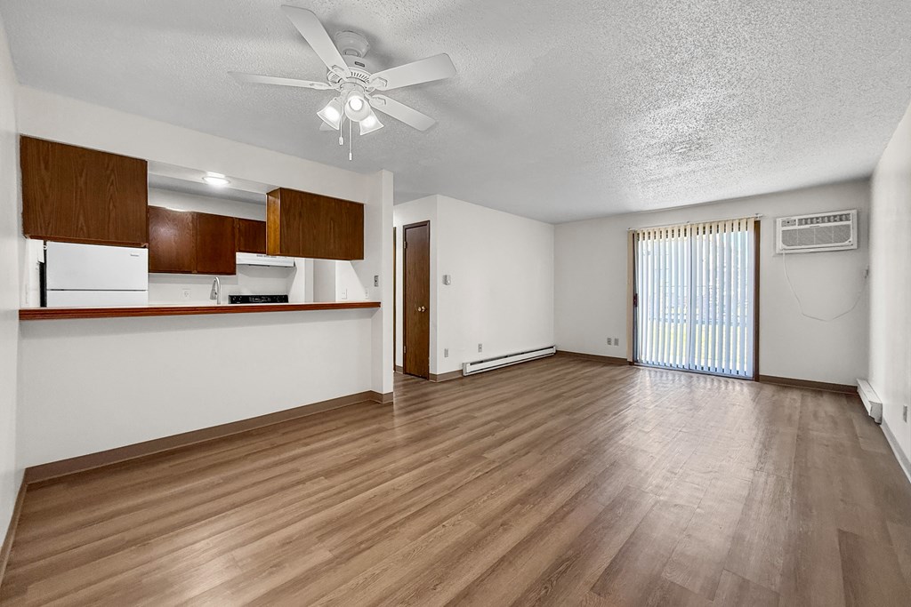 A room with wooden flooring and a ceiling fan.