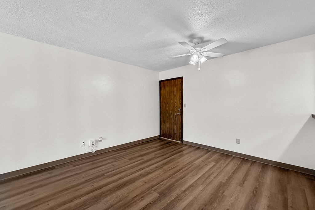 A room with a wooden floor and a ceiling fan.