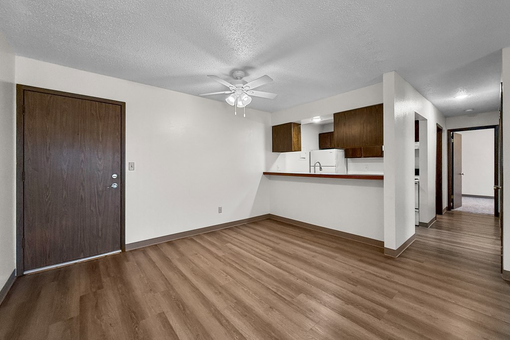 A room with wooden floors and a brown door.