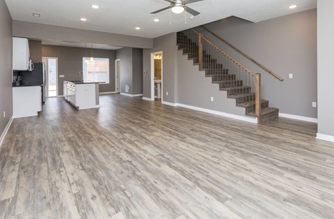 A spacious living room with a staircase leading to the upper floor.