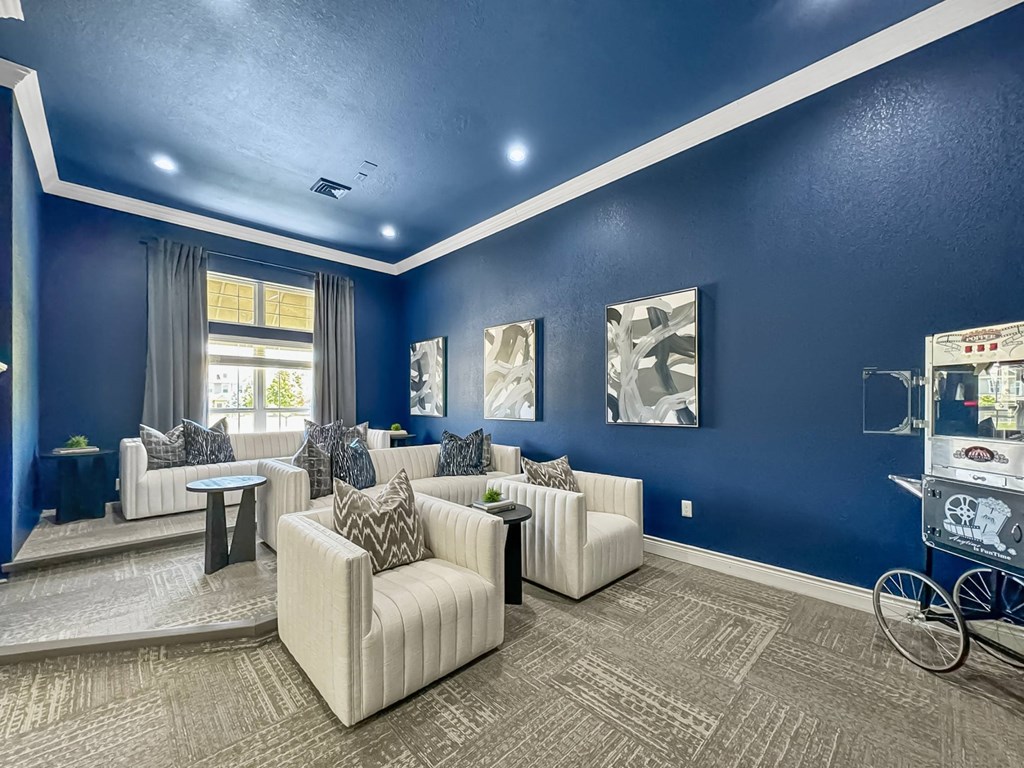 a living room with blue walls and white couches and chairs at 92West, West Des Moines, 50266  