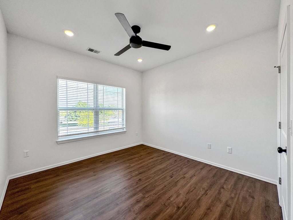 an empty living room with a ceiling fan and a window at 92West, Iowa, 50266