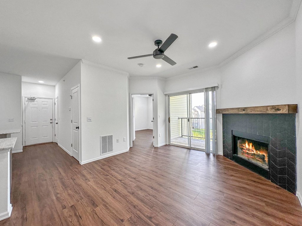 a living room with a fireplace and wooden floors at 92West, West Des Moines, 50266  