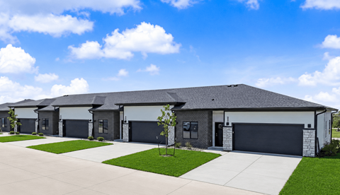 A row of houses with garages and driveways.