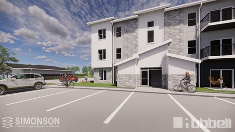 A modern apartment complex with a parking lot in front.