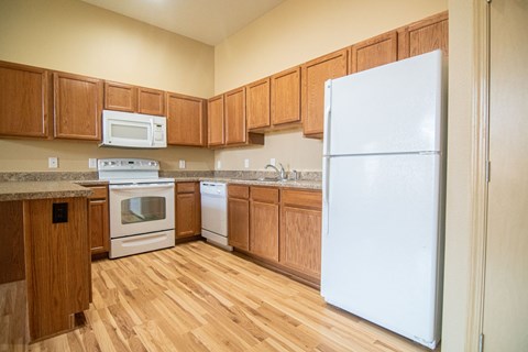 A kitchen with wooden cabinets and a white refrigerator.