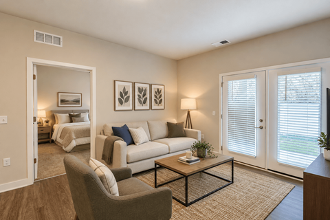 A living room with a couch, chair, and pictures on the wall.