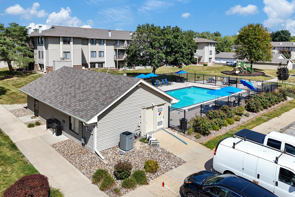 A swimming pool is surrounded by a fence and a building.