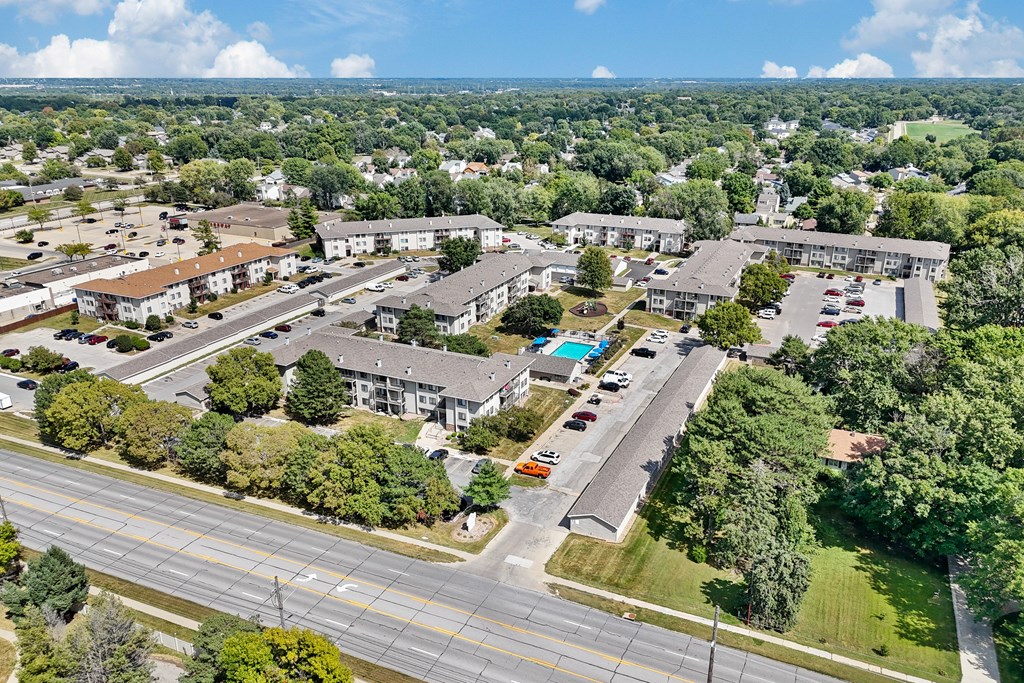 A bird's eye view of a suburban area with roads, cars, and buildings.