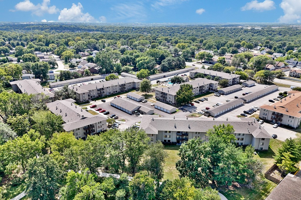 A bird's eye view of a residential complex surrounded by trees.