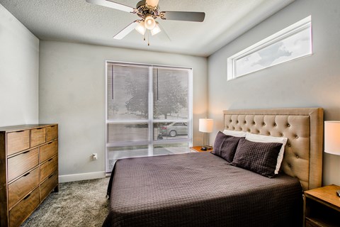 A bedroom with a bed, dresser, and window.