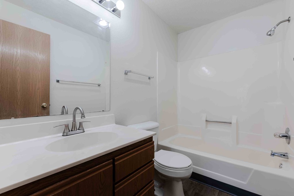 A white bathroom with a toilet, sink, and bathtub.