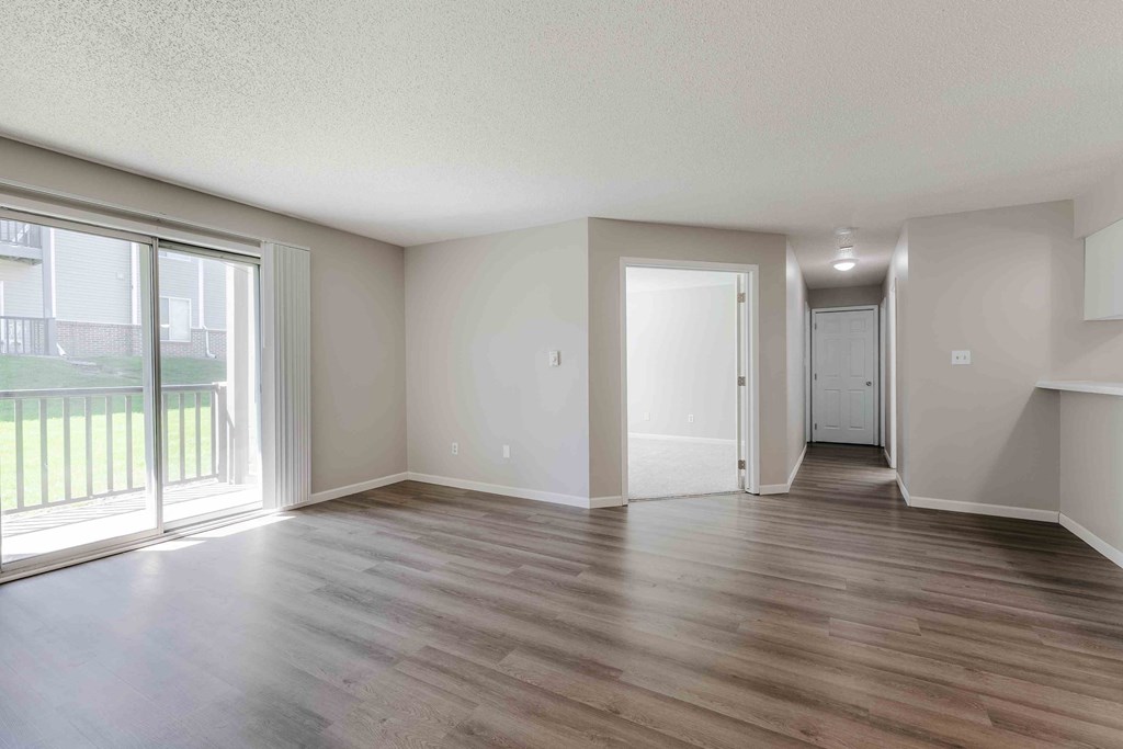 A room with wooden flooring and white walls.