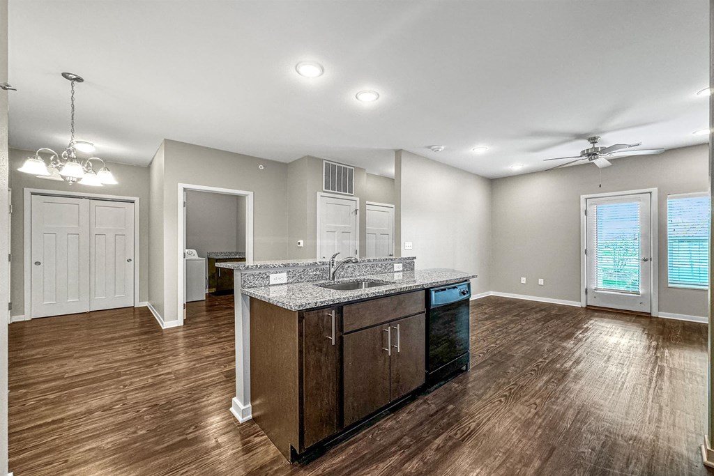 an empty living room with a kitchen with a counter top at The Barclay Apartments, Altoona