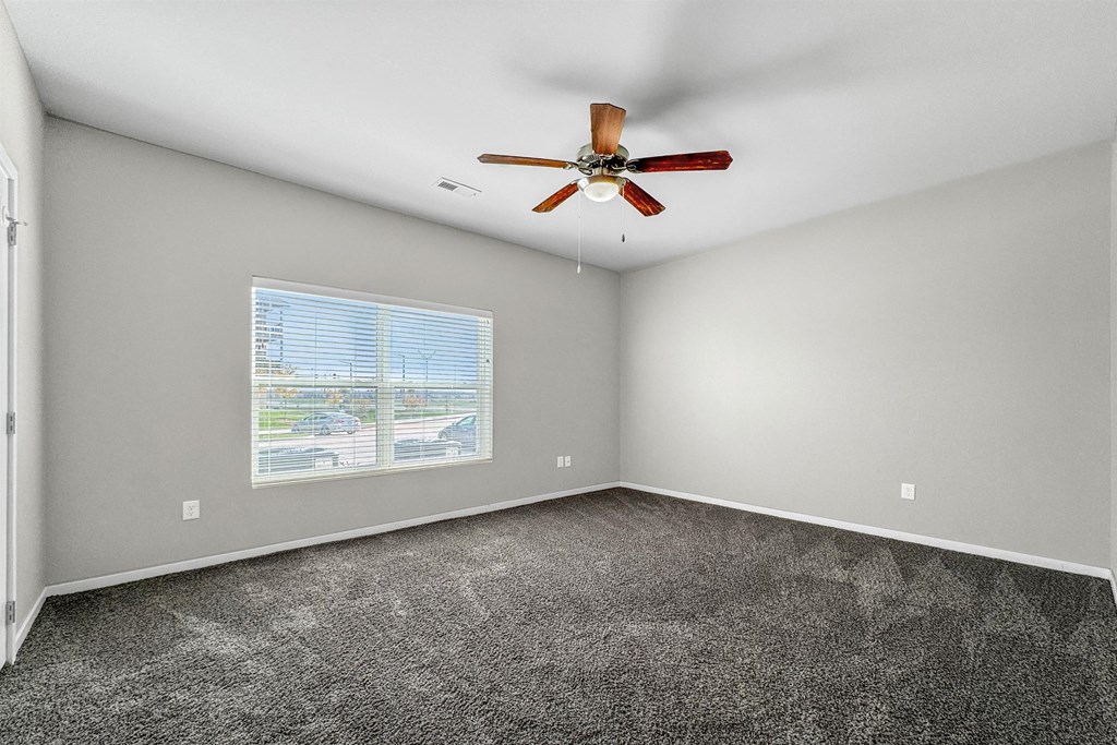 A room with a ceiling fan and a window with blinds. at The Barclay Apartments, IOWA