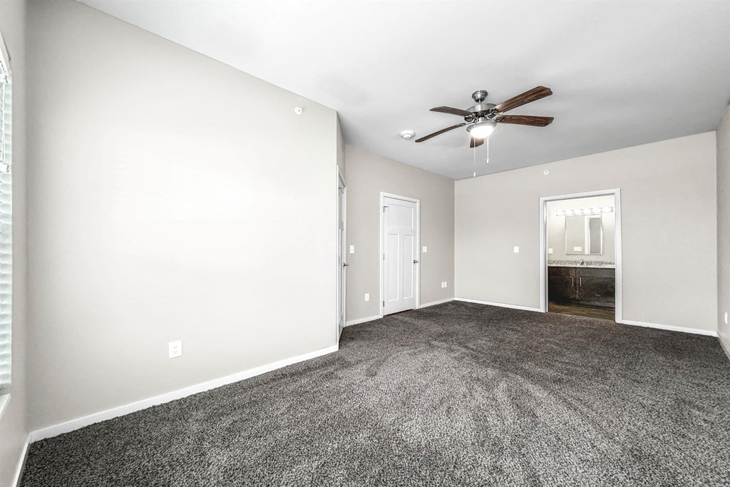 A room with a ceiling fan and carpeted floor at The Barclay Apartments, IOWA, 50009