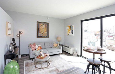 A living room with a couch, a table, and a painting on the wall.