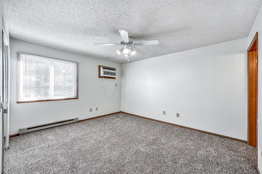 A room with a ceiling fan and a window with blinds at Somerset Apartments, Iowa