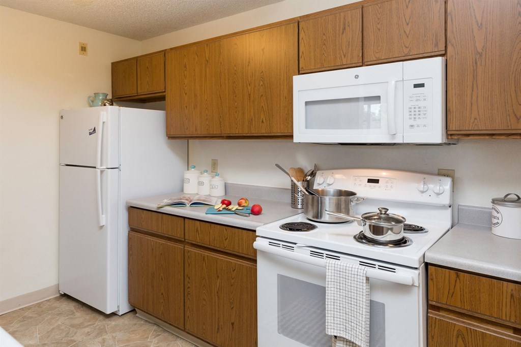 a kitchen with a stove microwave and refrigerator at Somerset Apartments, Des Moines, IA