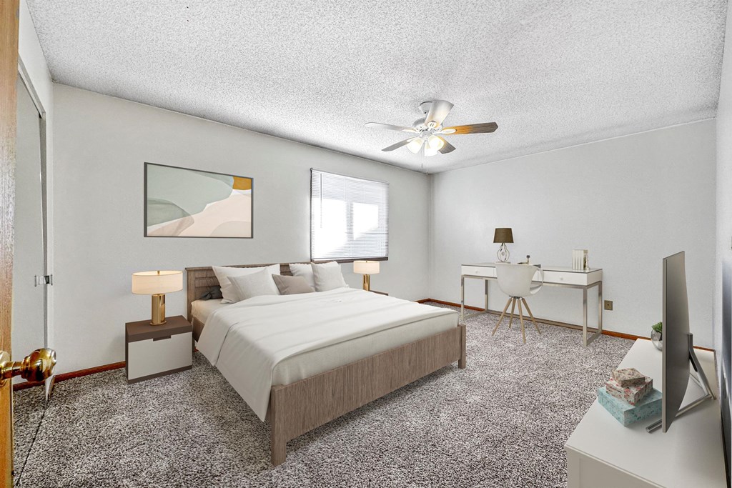 a bedroom with a large bed and a ceiling fan at Somerset Apartments, Des Moines