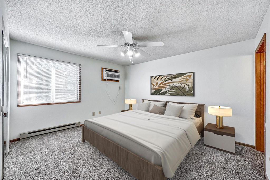a bedroom with a large bed and a ceiling fan at Somerset Apartments, Iowa, 50315