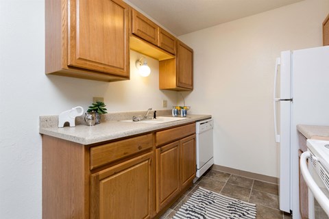 A kitchen with wooden cabinets and a white fridge.