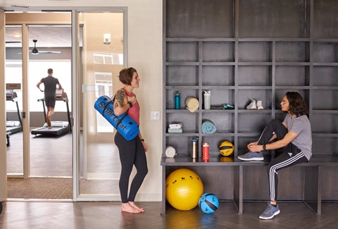 two women working out in a gym with weights and a yoga ball at Velocity Apartments, IA, 50309