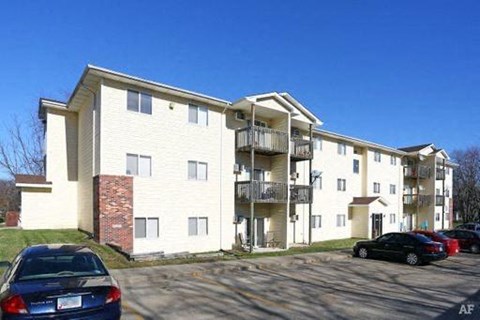 an apartment building with cars parked in front of it