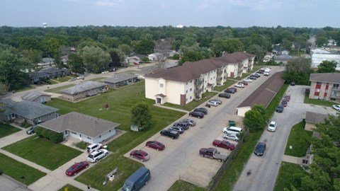 an aerial view of a neighborhood with cars parked on the street