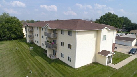 an aerial view of an apartment building with a yard and grass