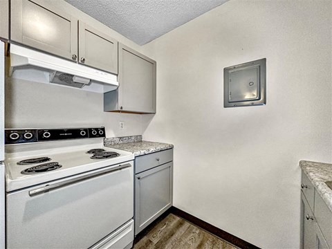 A small kitchen with a white stove and a white oven.
