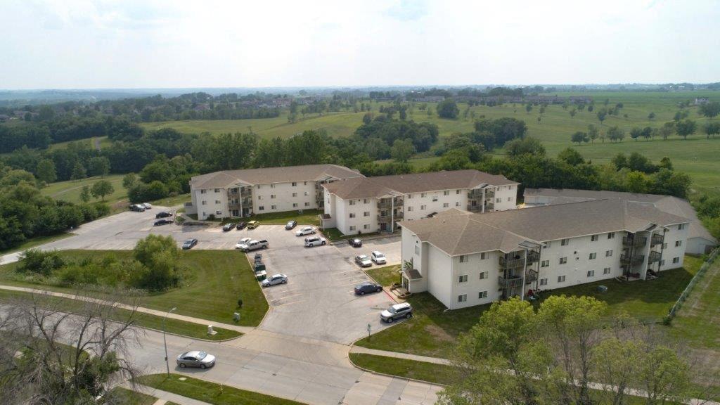 A large white building with a parking lot in front of it.