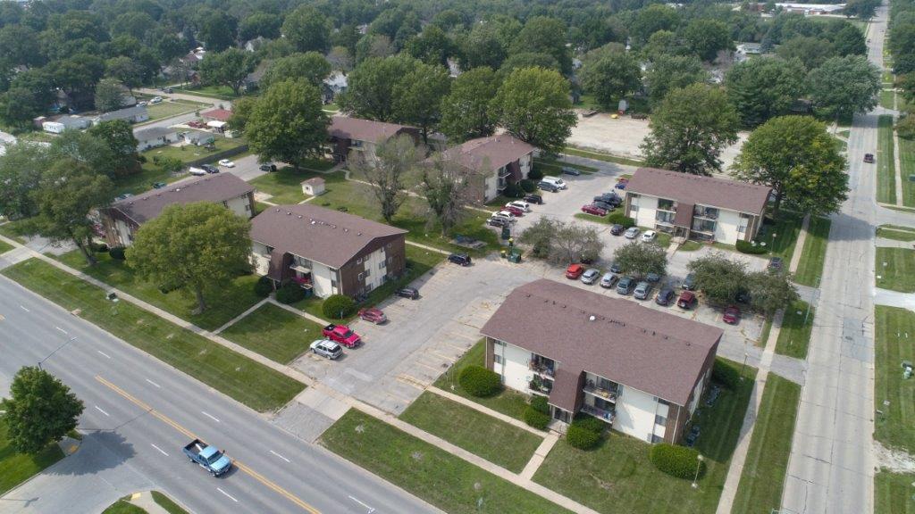 an aerial view of a neighborhood of houses with cars parked on the street