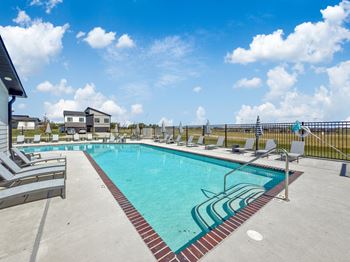 our apartments have a resort style pool with lounge chairs at Rialto Townhomes Apartments, Waukee, IA