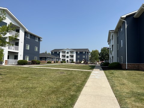 A grassy area in front of apartment buildings.