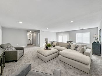 a large living room with a couch and a chair at Rialto Townhomes Apartments, Iowa, 50263