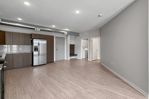 A spacious kitchen with a refrigerator, cabinets, and a countertop.