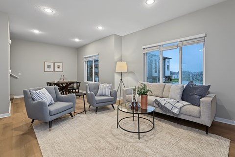 A living room with a grey sofa, two armchairs, and a coffee table.