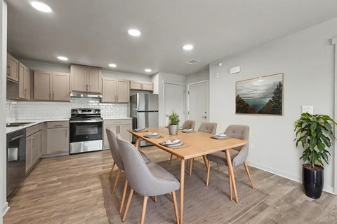 A modern kitchen with a dining table set for four.