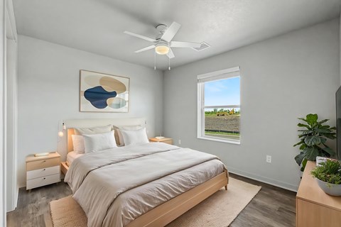 Bedroom with light wood furniture and ceiling fan at The Collective on 13th Apartments, Charles City, IA 50616