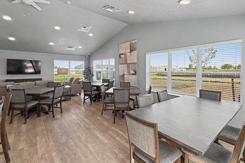 Community room with dining tables and lounge seating at The Collective on 13th Apartments, Charles City, IA 50616